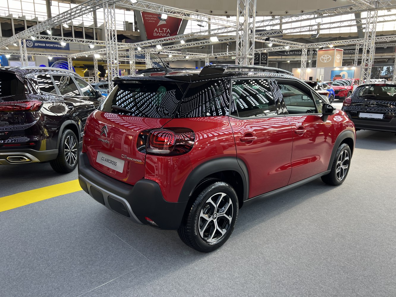 Rear and side view of red compact SUV with black roof and distinctive rear lights