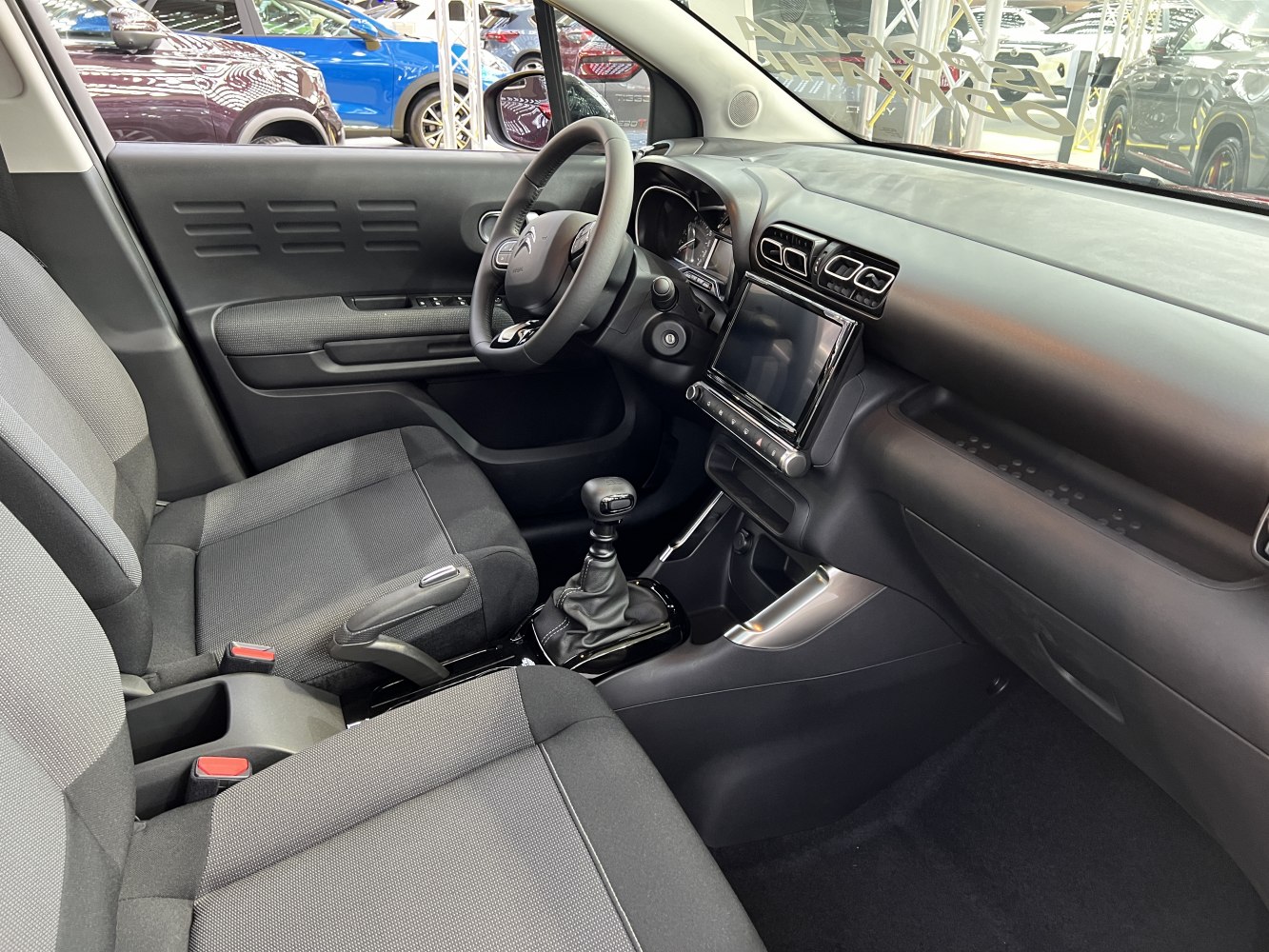 Manual gearshift, touchscreen, ergonomic seating in a modern compact interior