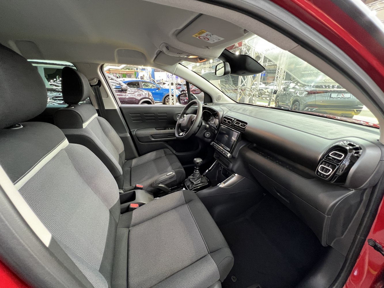 Front cabin with dashboard, manual gearshift, and two-tone fabric seats