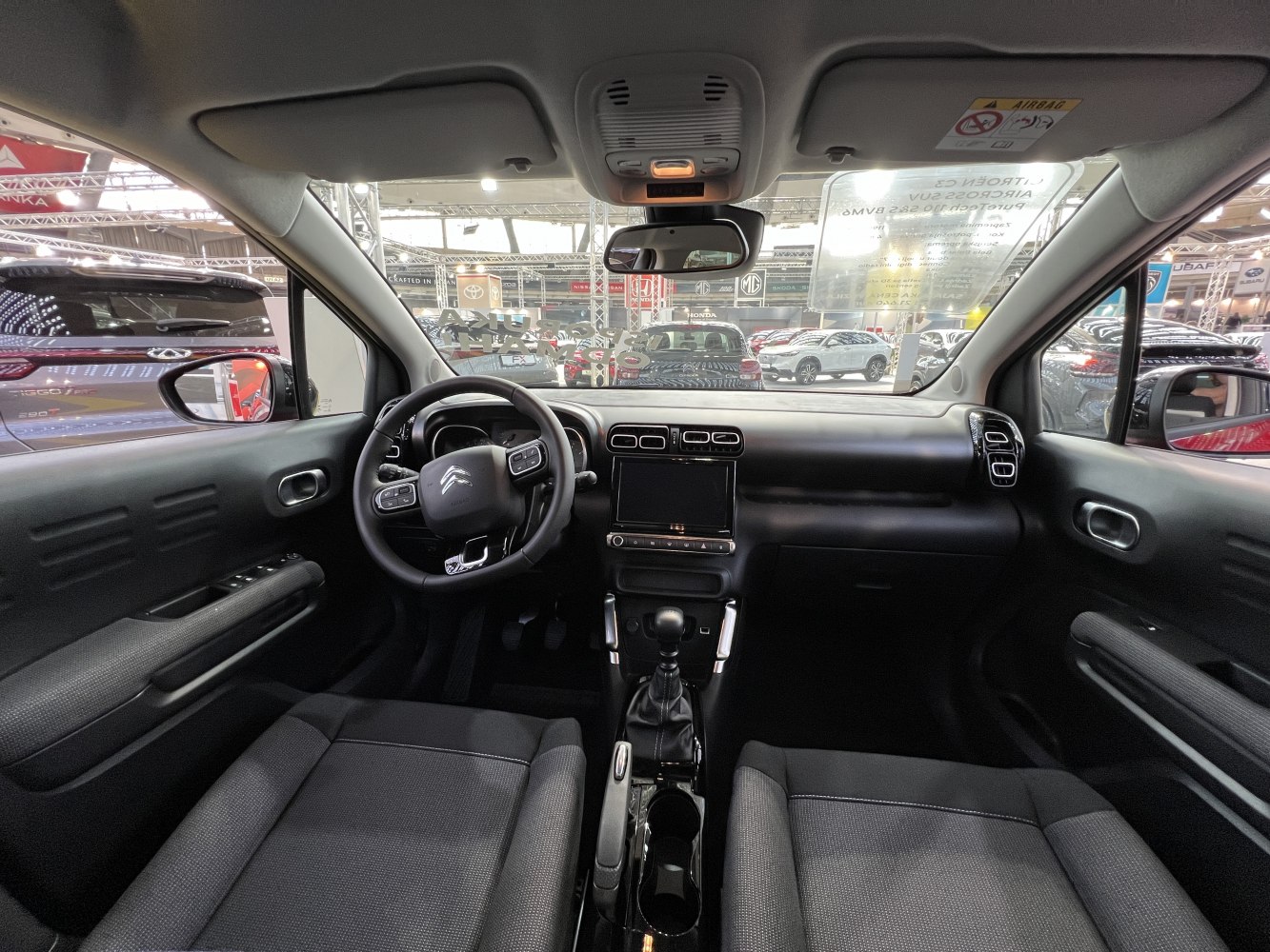 Dashboard view with steering wheel, center console, and car seats