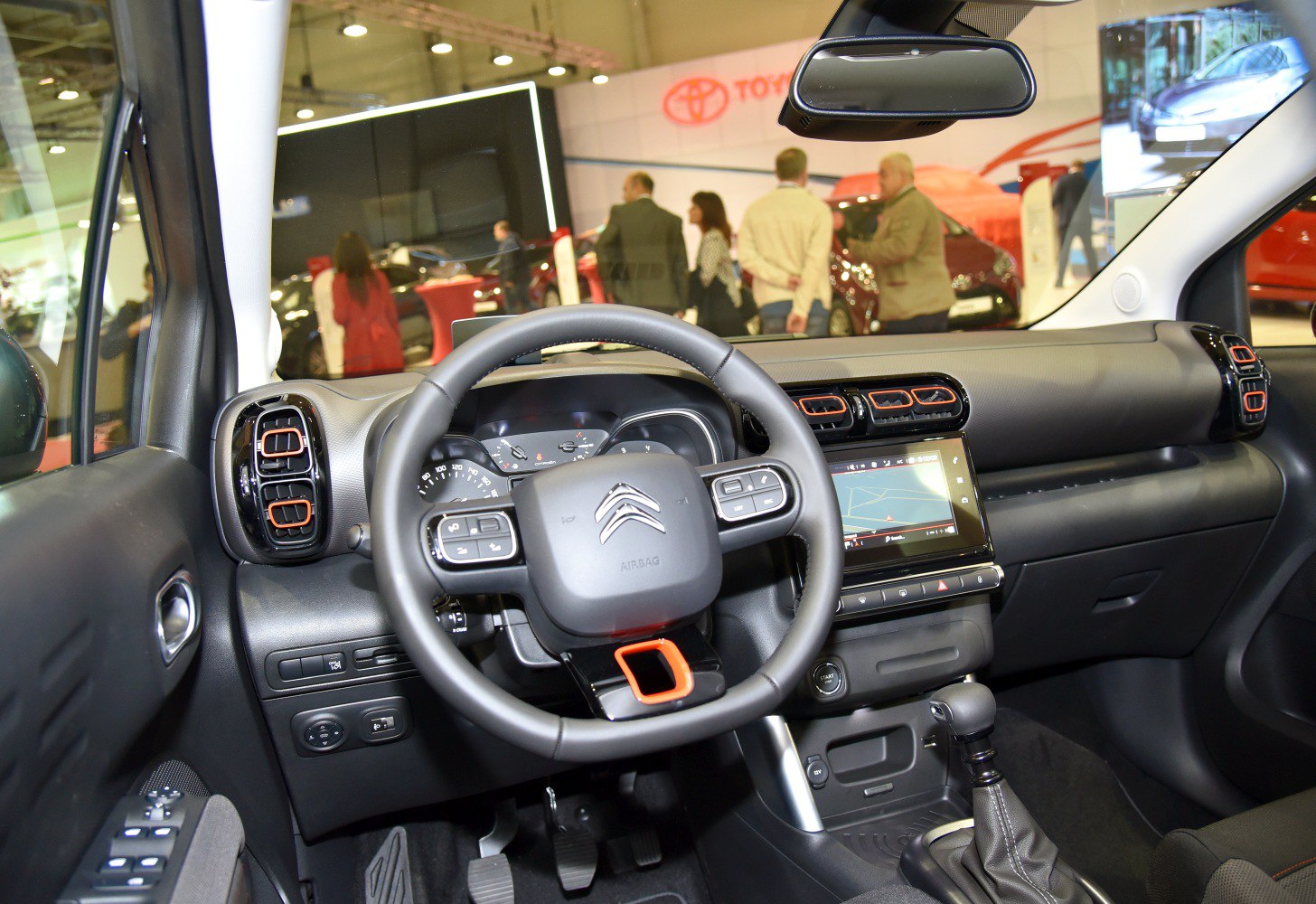 Dashboard, steering wheel with controls, touchscreen, air vents.