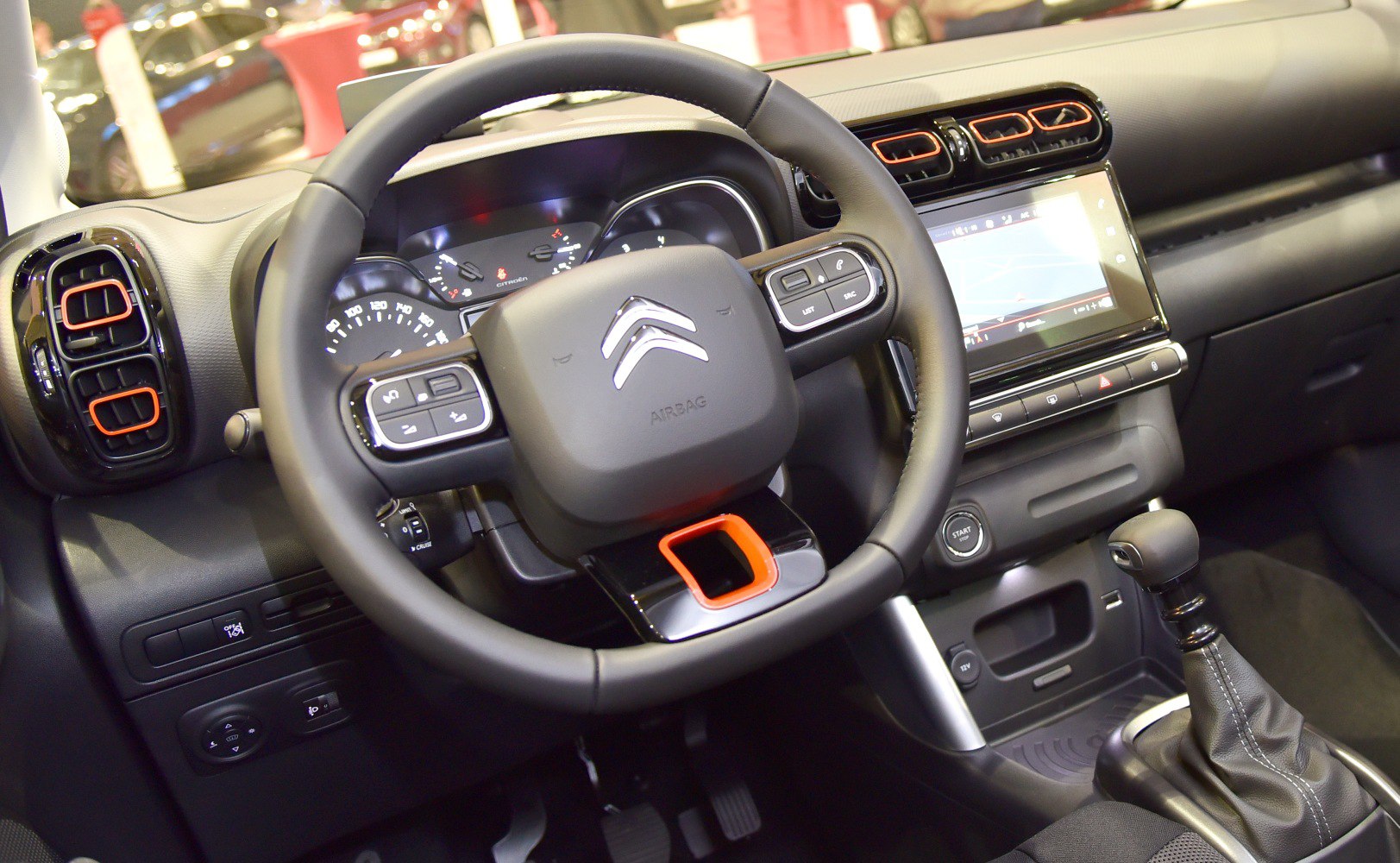 Steering wheel with controls and dashboard with infotainment screen