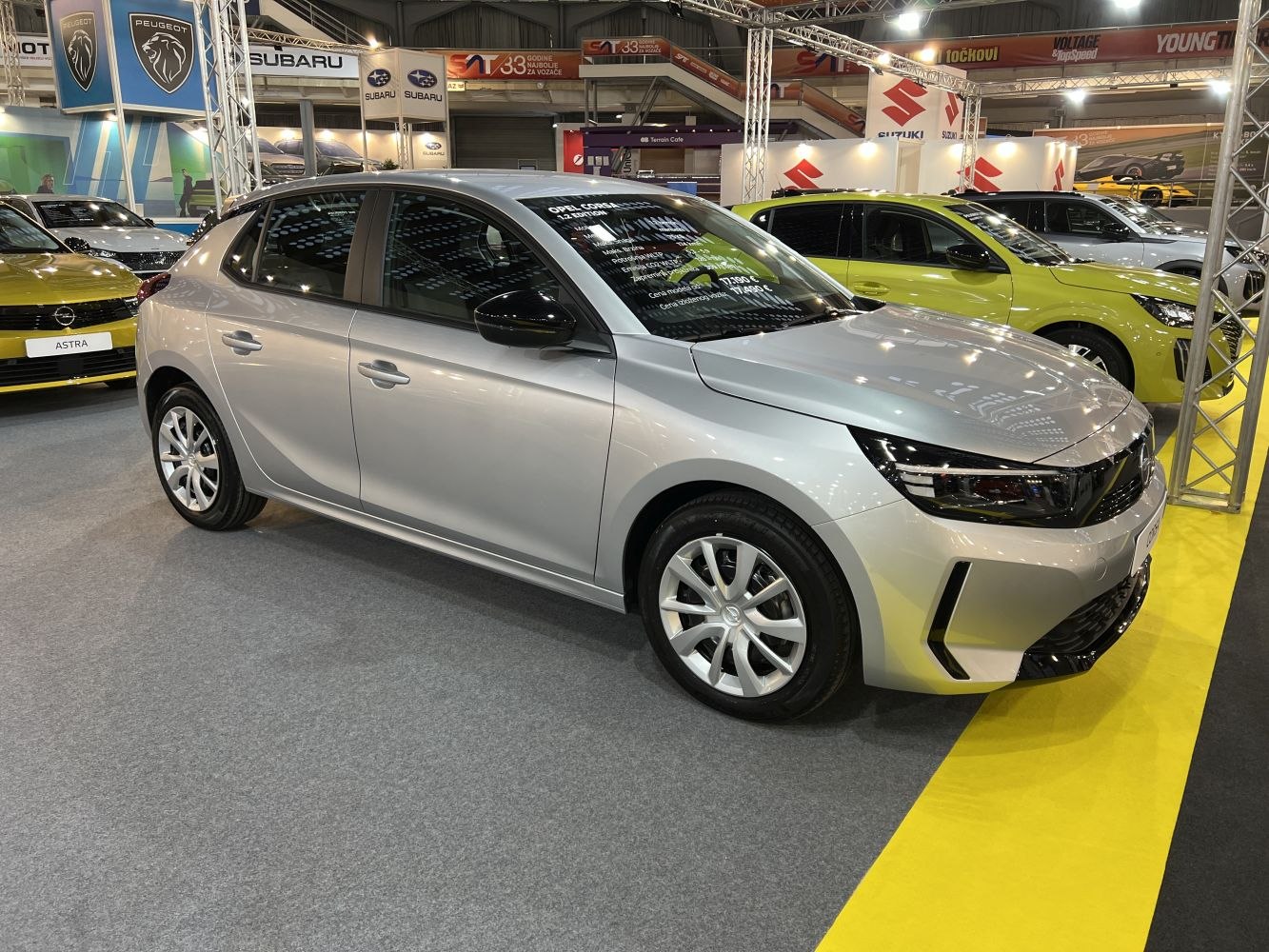 Silver five-door hatchback with sleek headlights and sporty design.