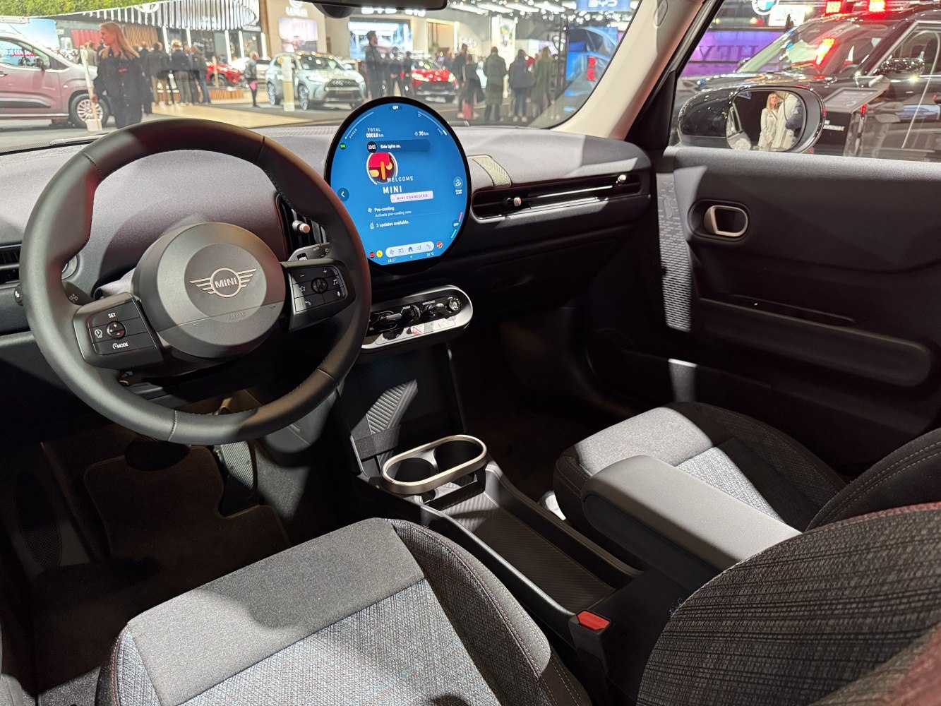 Circular digital display and modern steering wheel in compact vehicle interior