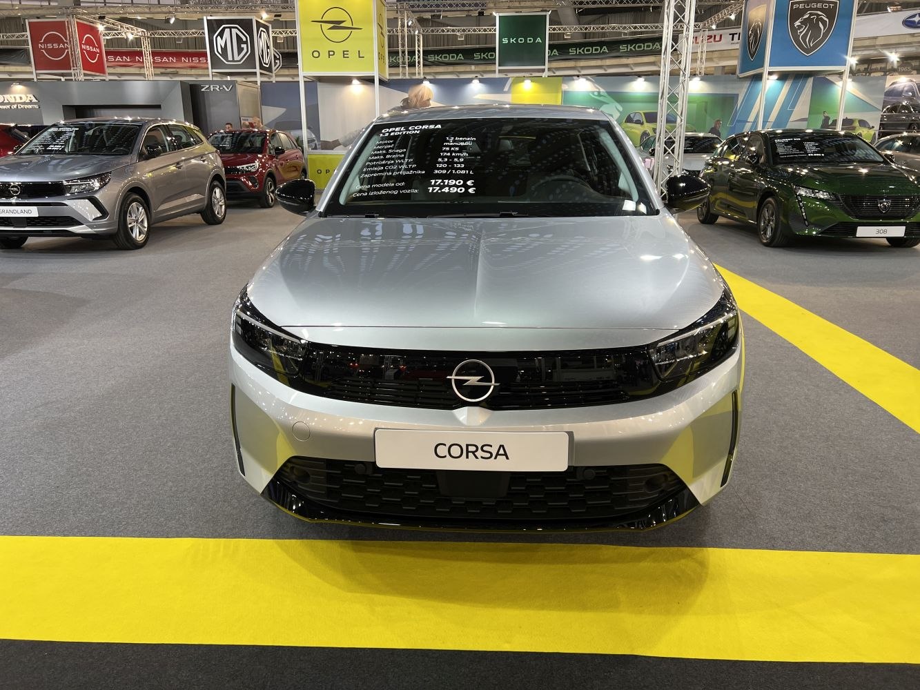 Front view of silver compact hatchback with sleek grille and badge.