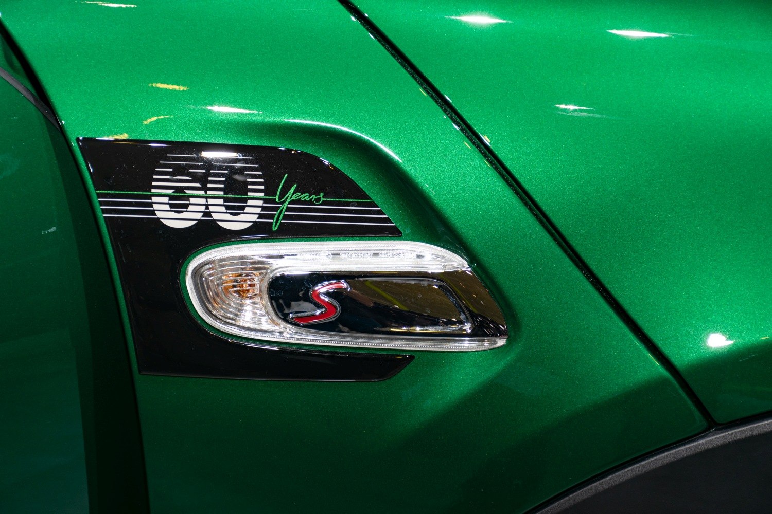 Side marker and 60 years emblem on green metallic surface