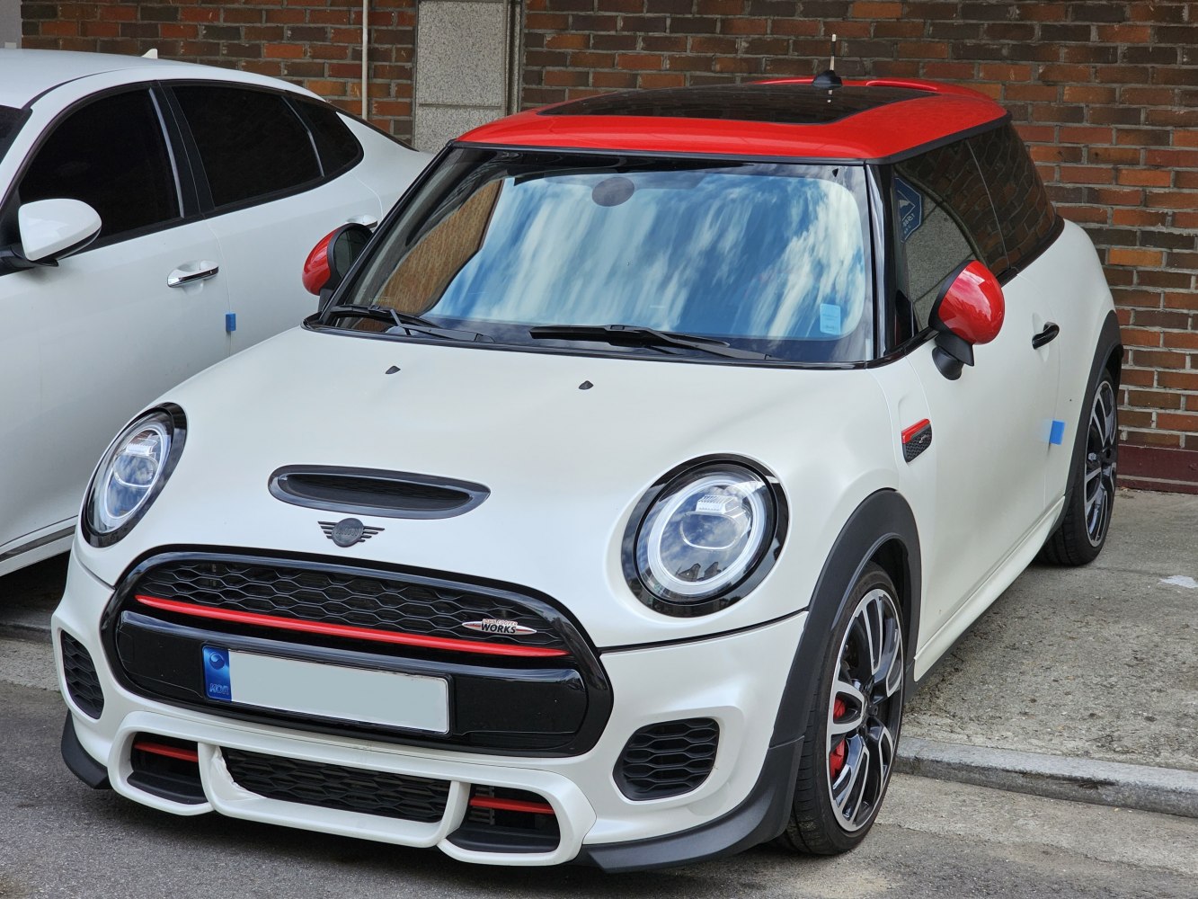 Sporty front with round LED headlights and contrasting red roof and mirrors