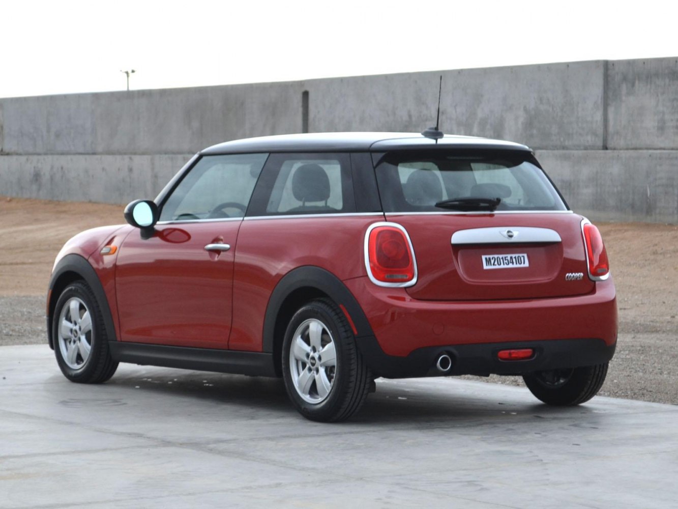 Rear-side view of red 3-door hatchback with black roof and distinctive rear lights