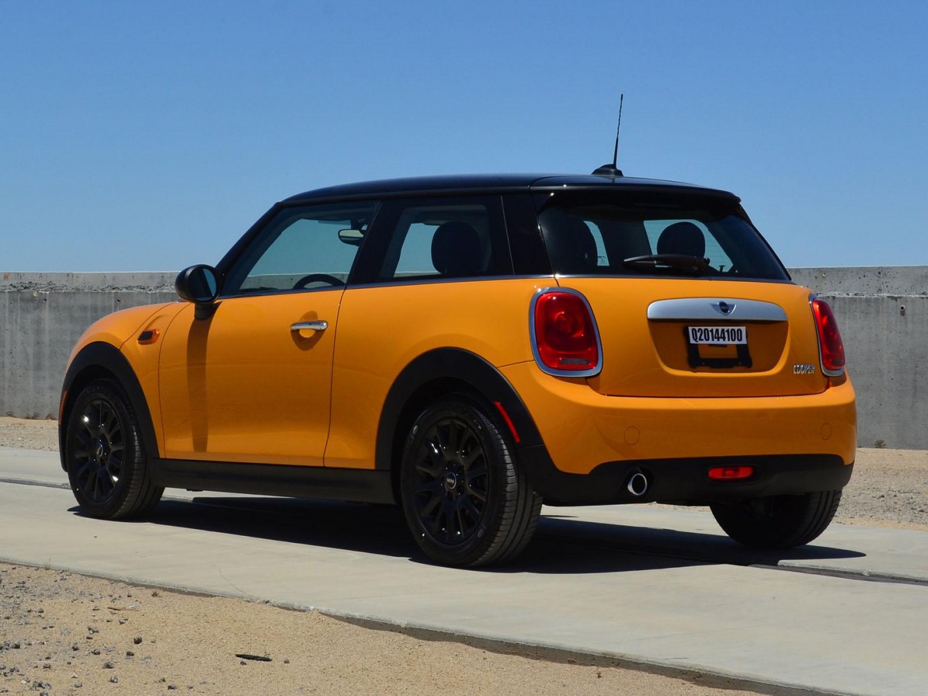 Yellow compact hatchback with black roof and alloy wheels rear-side view