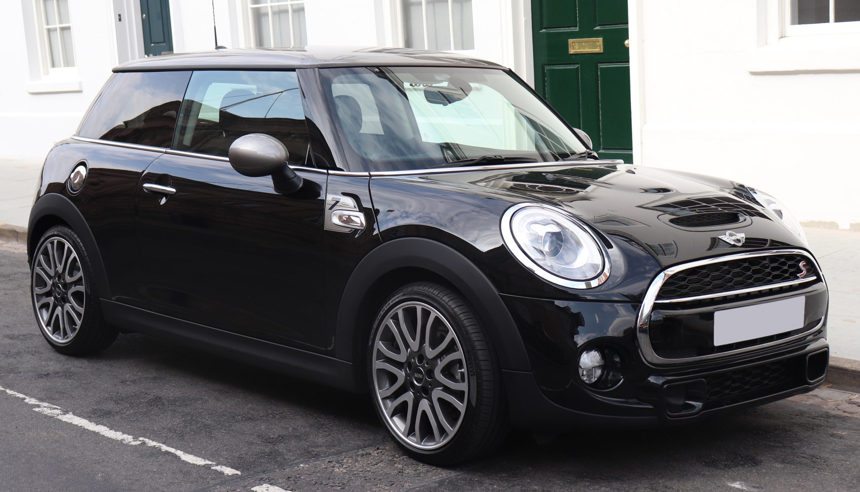 Black compact hatchback with round headlights and sporty alloy wheels