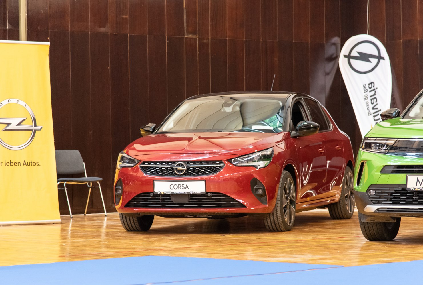 Red compact hatchback with sleek front grille and LED headlights