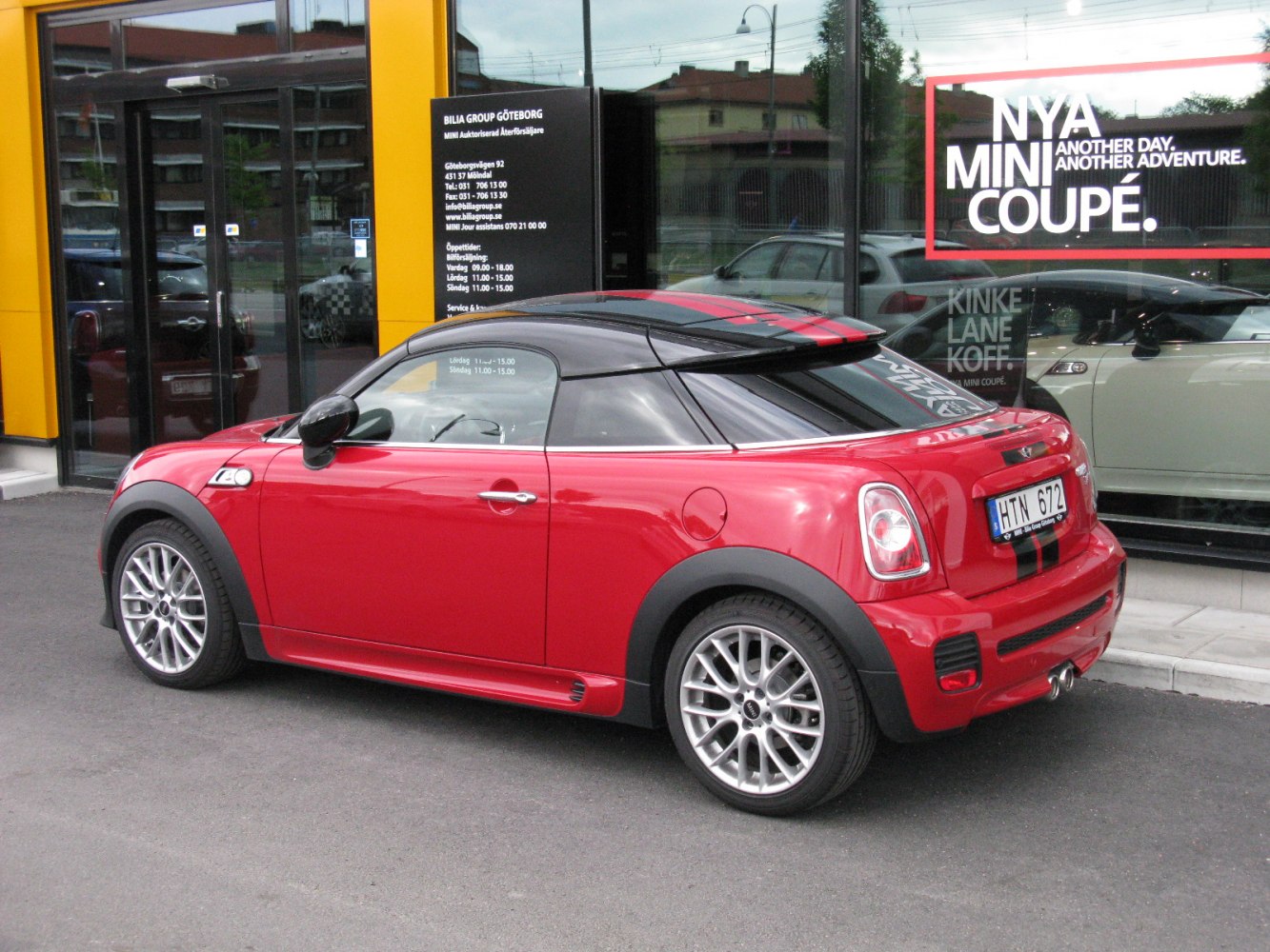 Red compact coupe with black roof and alloy wheels