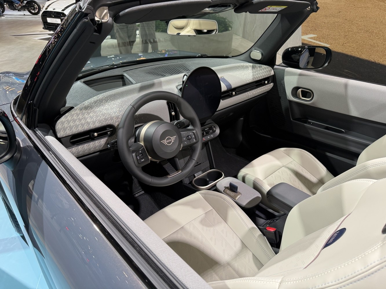 Modern convertible interior with round digital display and luxury seats