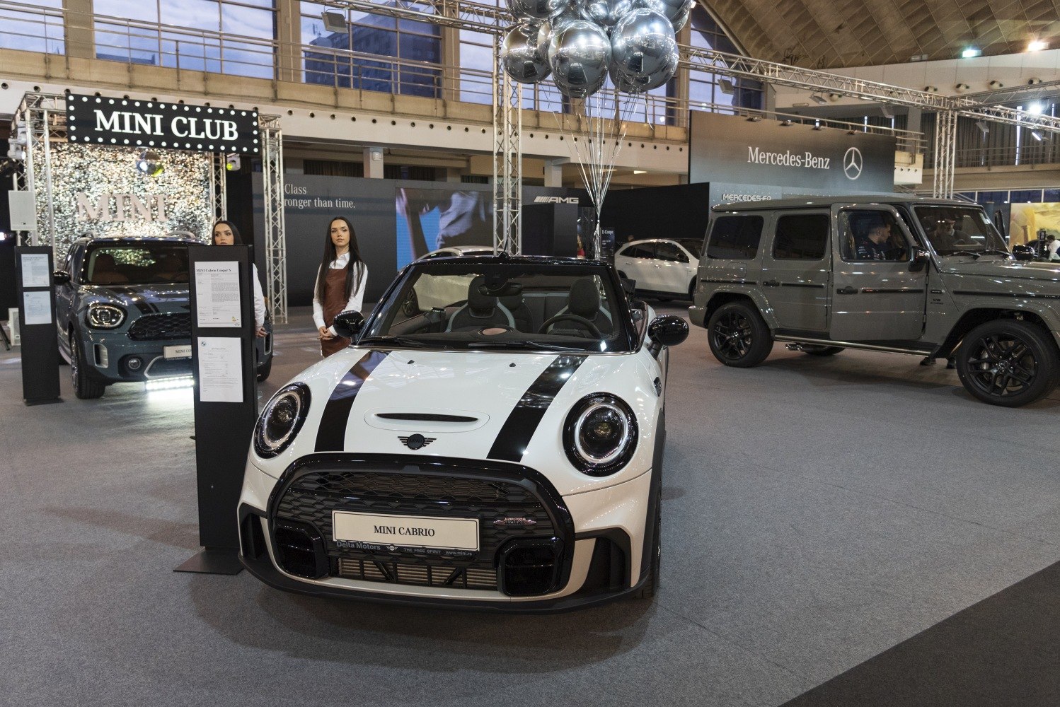 White Mini Convertible with black racing stripes and open roof, front view