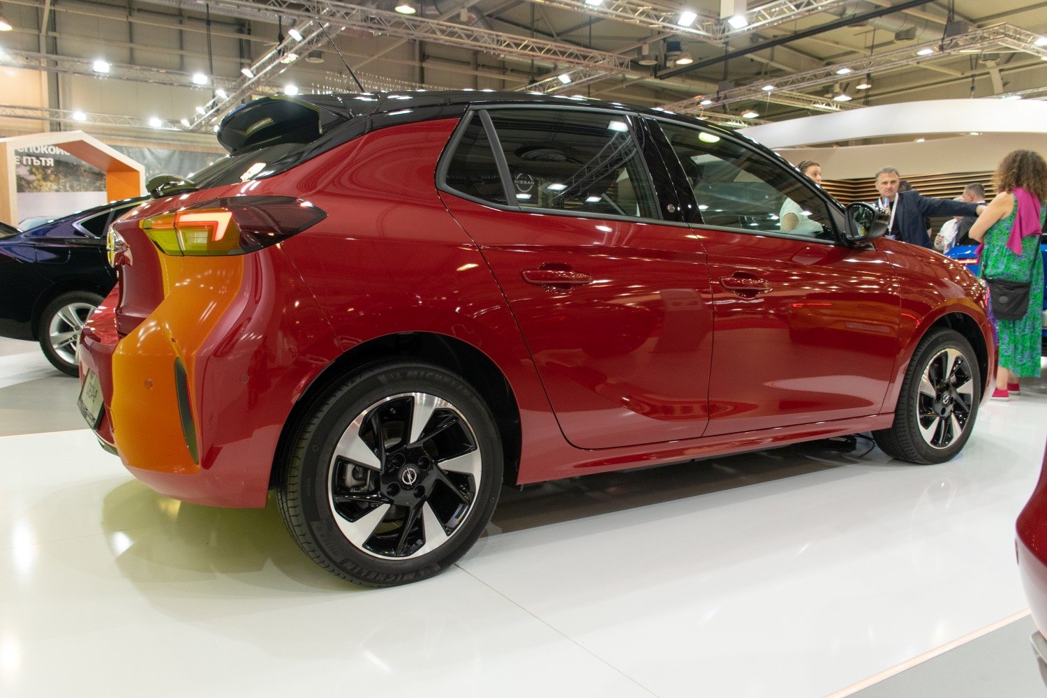 Rear side view of a red hatchback with black alloy wheels and distinctive taillights