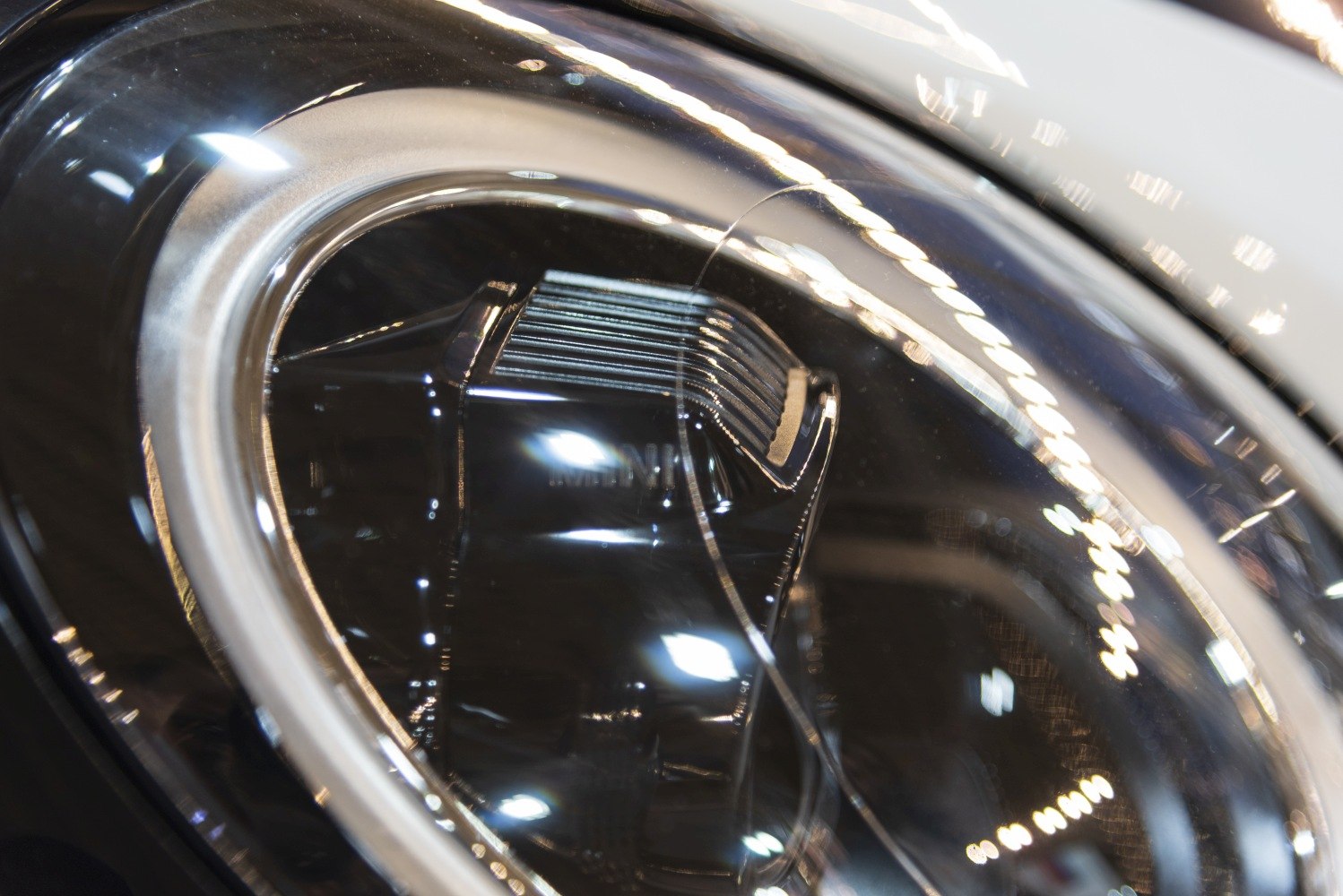 Close-up of a modern circular car headlight with LED elements and clear glass cover