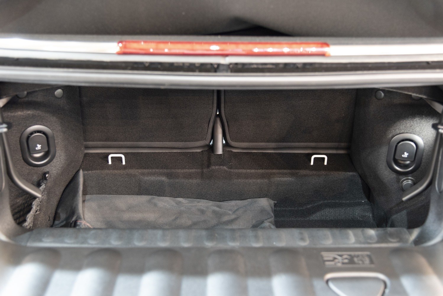 Compact trunk interior with seat release buttons and foldable rear seats.
