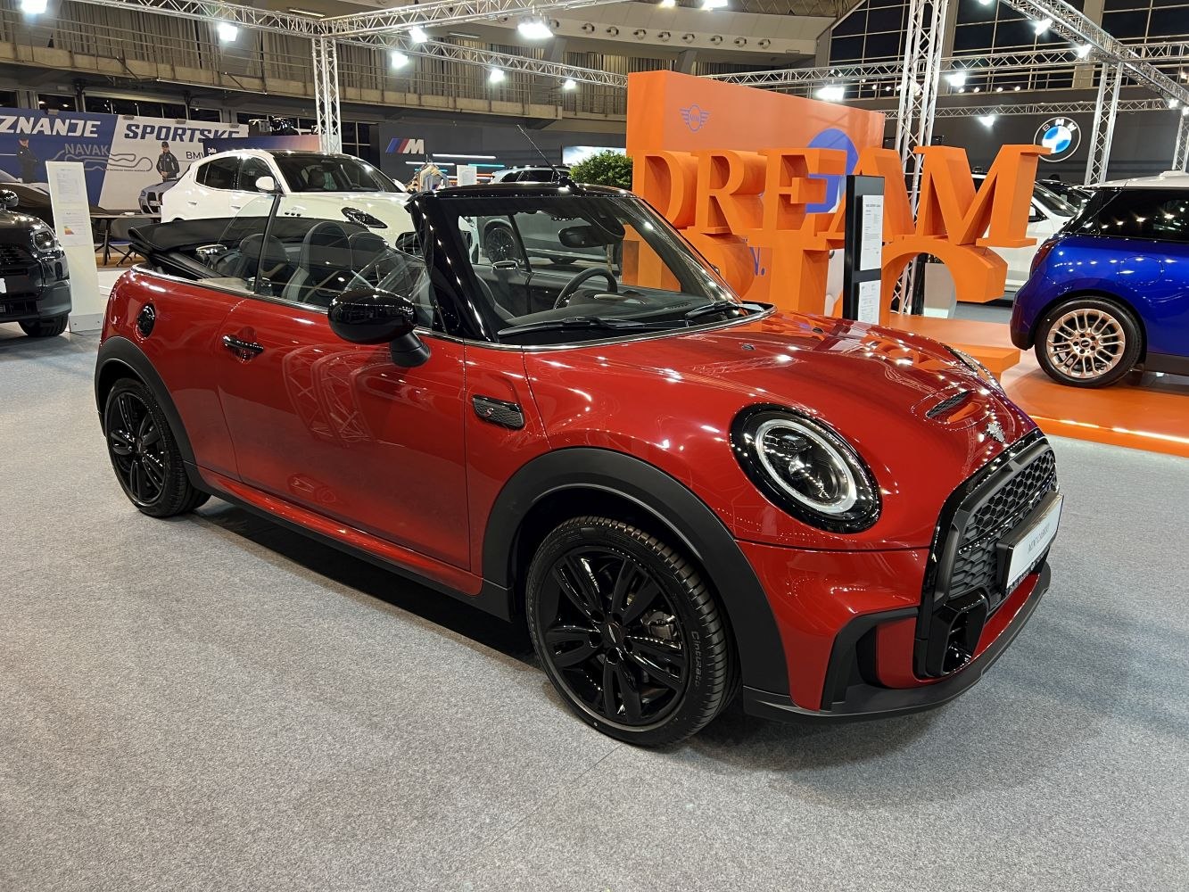 Red convertible with black wheels and lowered soft top roof