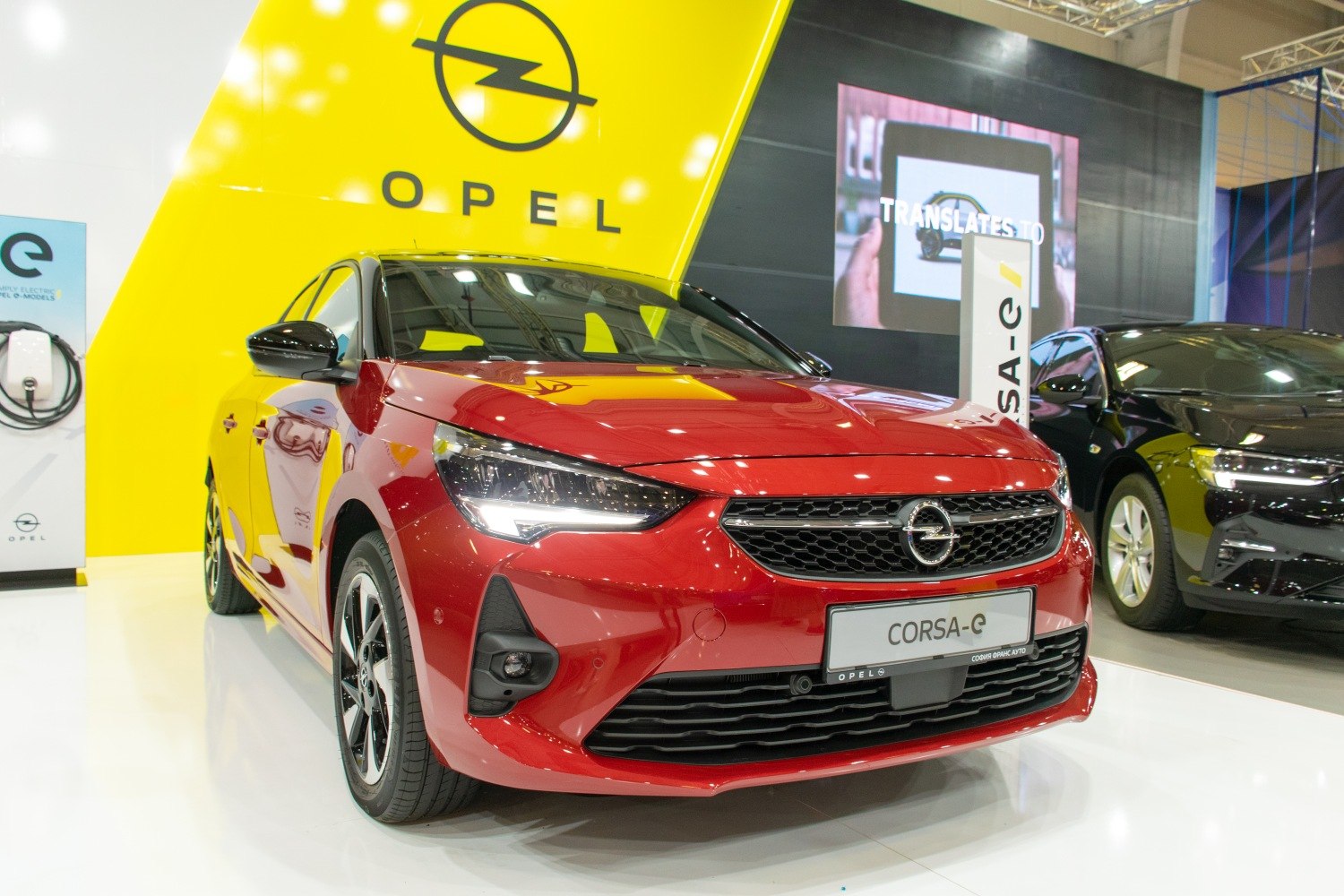 Front view of red hatchback with modern headlights and grille