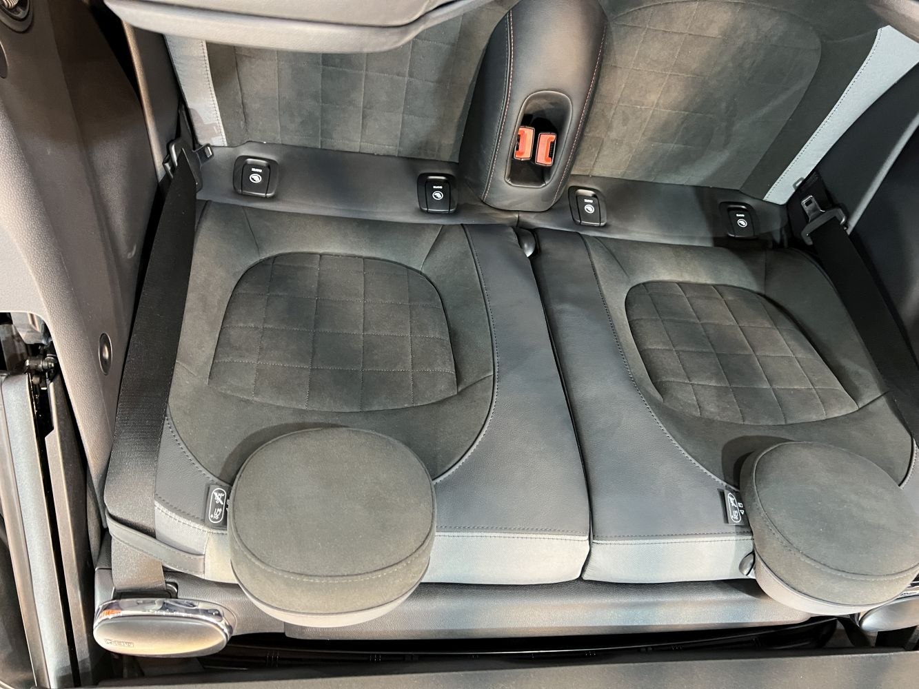 Quilted leather and suede rear seats with integrated headrests and seatbelt attachments