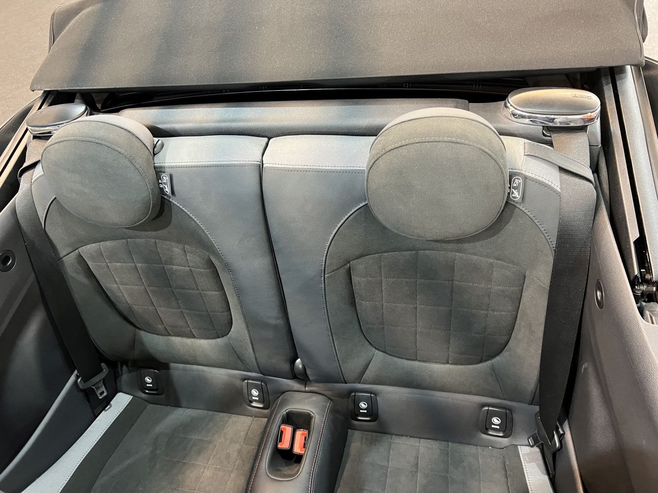 Rear seats with upright headrests and seatbelt design in convertible interior
