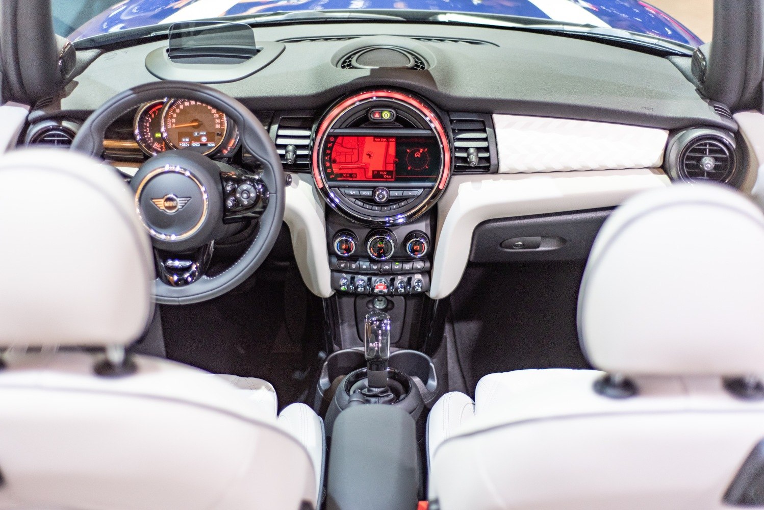 Interior with modern dashboard, circular infotainment, and steering wheel controls