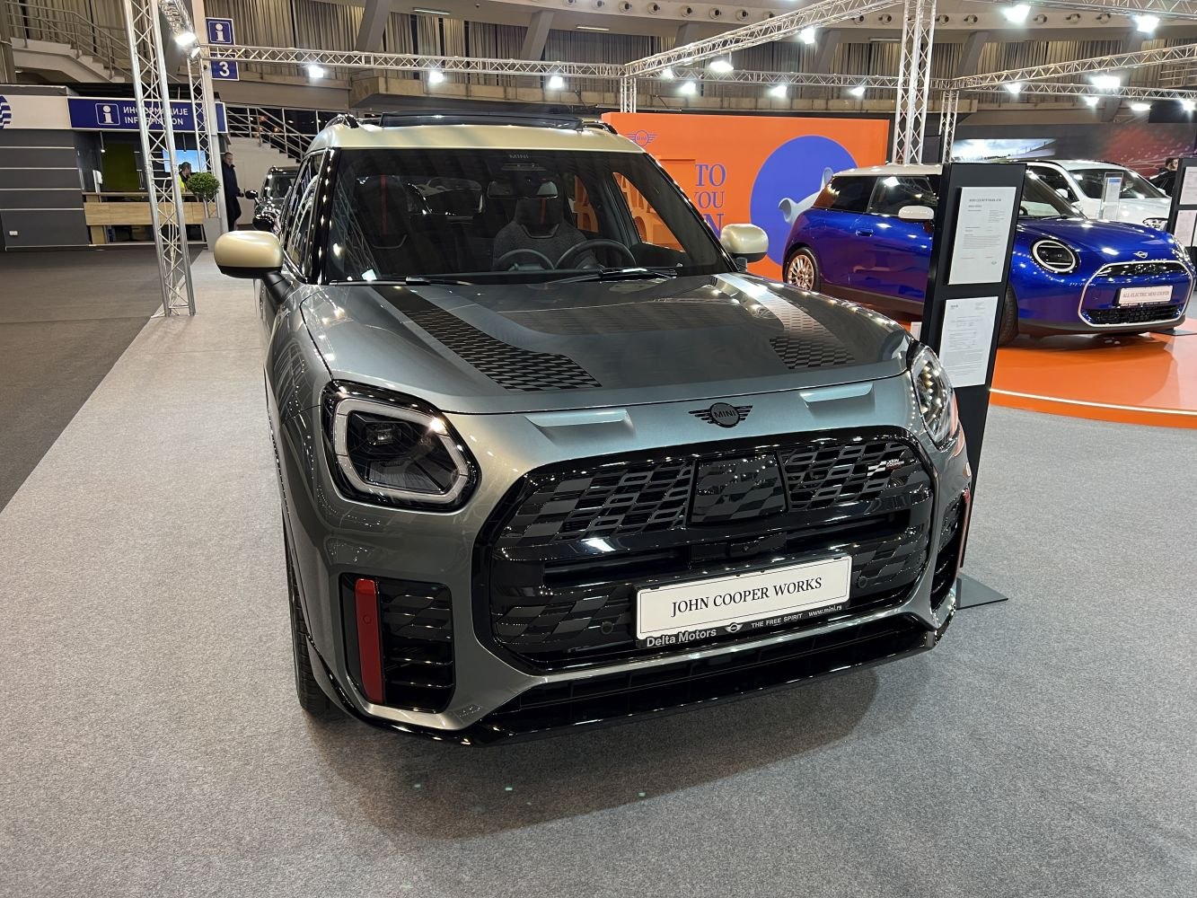 Front view with large black grille and sporty hood stripes