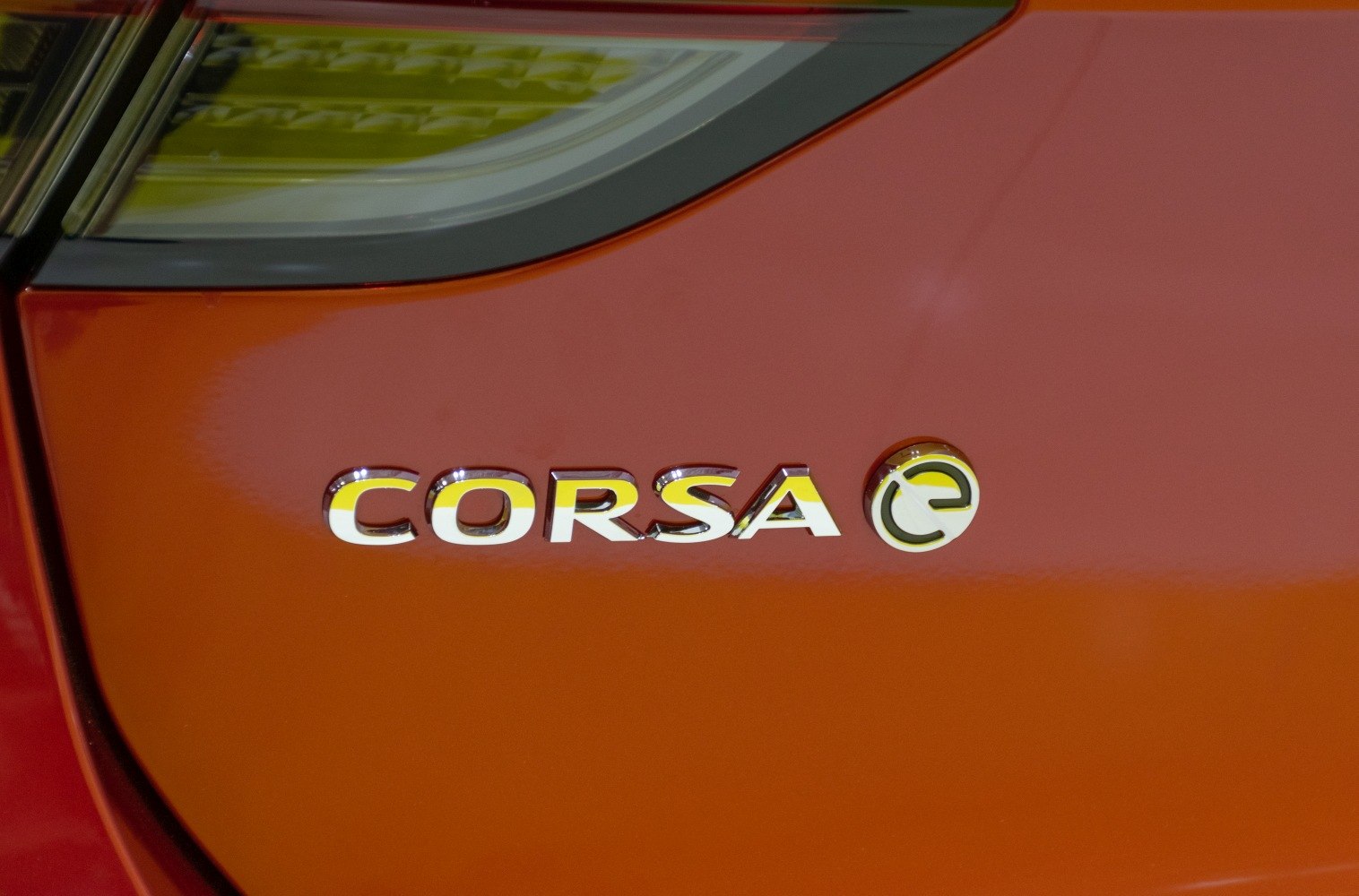 Close-up of Opel Corsa F electric badge on orange paint