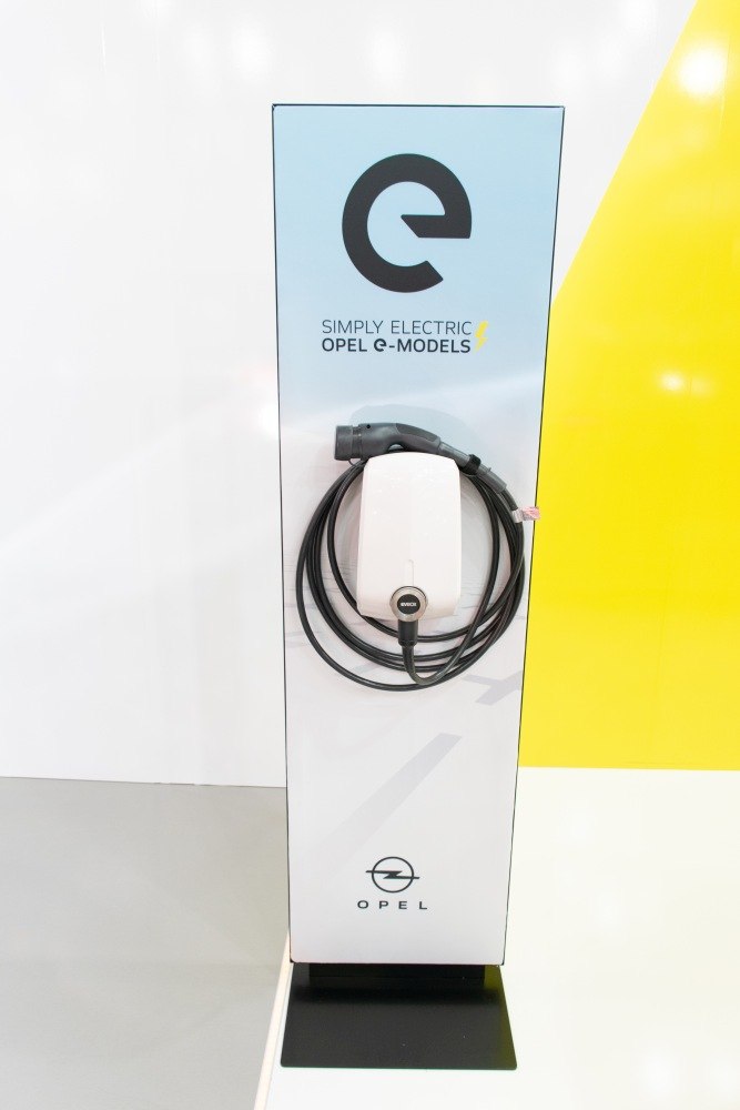 Electric vehicle charging station with charging cable and Opel branding