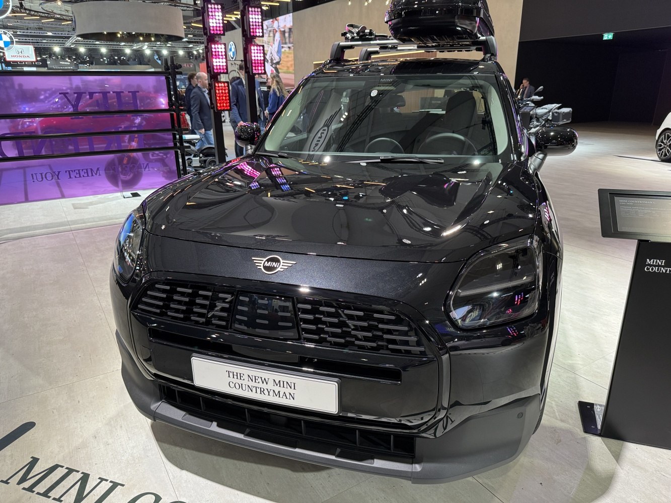 Close-up of front grille, headlights, and roof rack on a black Mini Countryman SUV