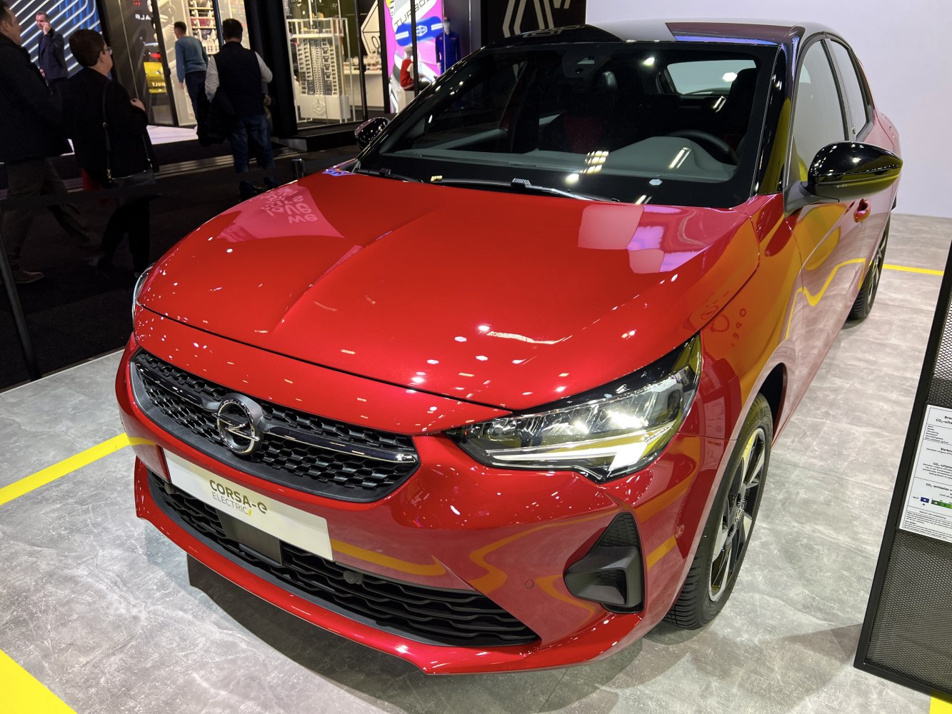 Front view of a red electric hatchback with LED headlights and black grille
