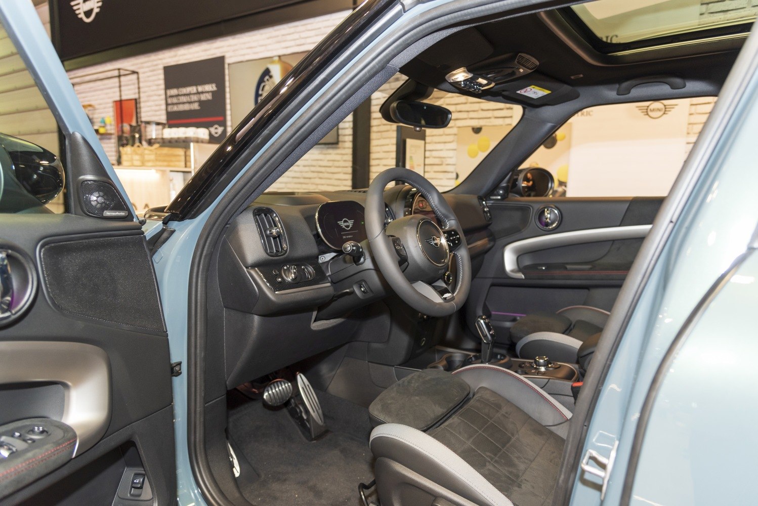 Modern car interior with steering wheel, dashboard, and panoramic sunroof