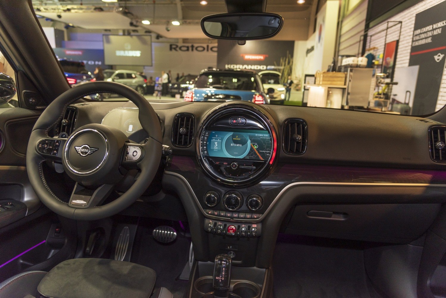 Dashboard, steering wheel, infotainment display, and center controls with ambient lighting