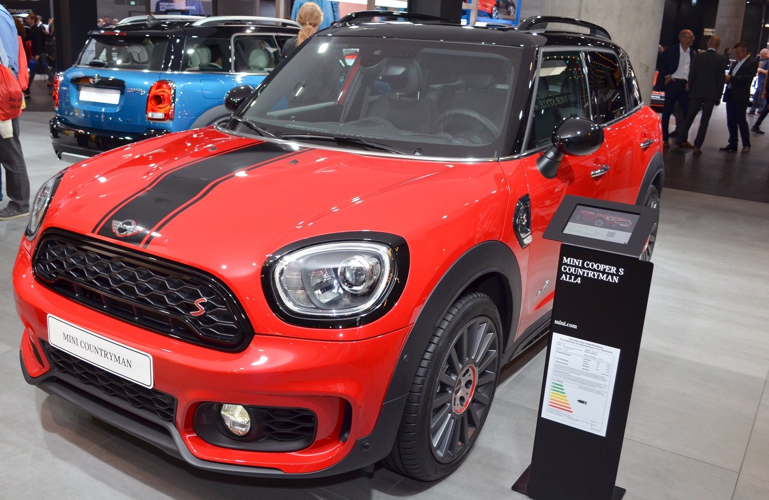 Front view of red compact SUV with black racing stripes and sporty grille