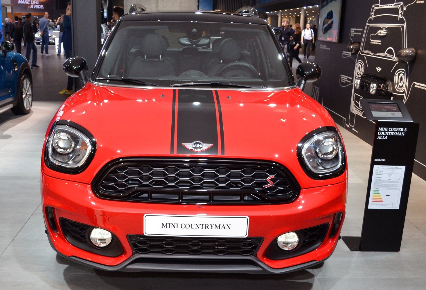 Black honeycomb grille and racing stripes on a red compact SUV front.