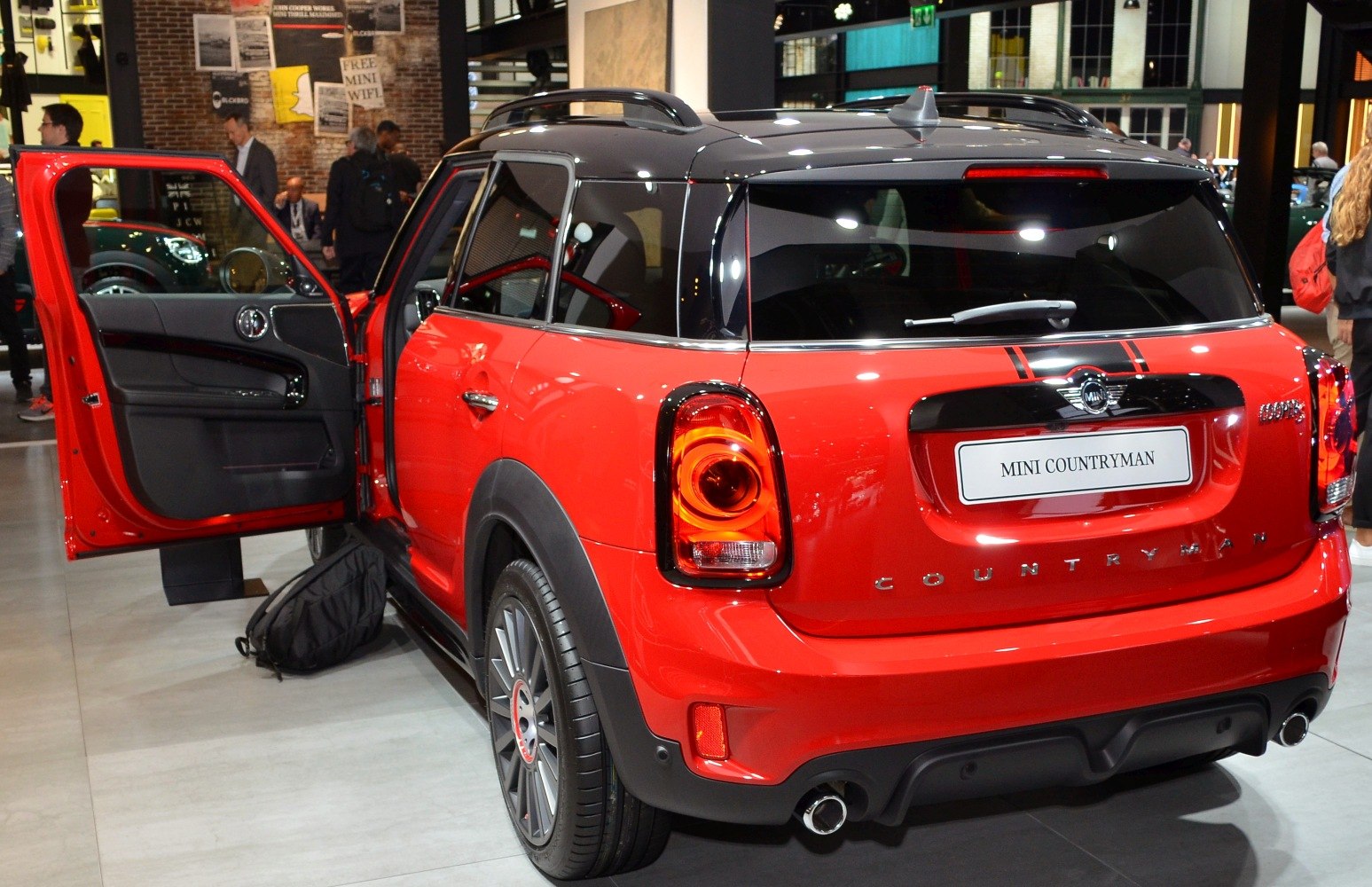 Rear and side view with open driver's door, black roof, and round taillights