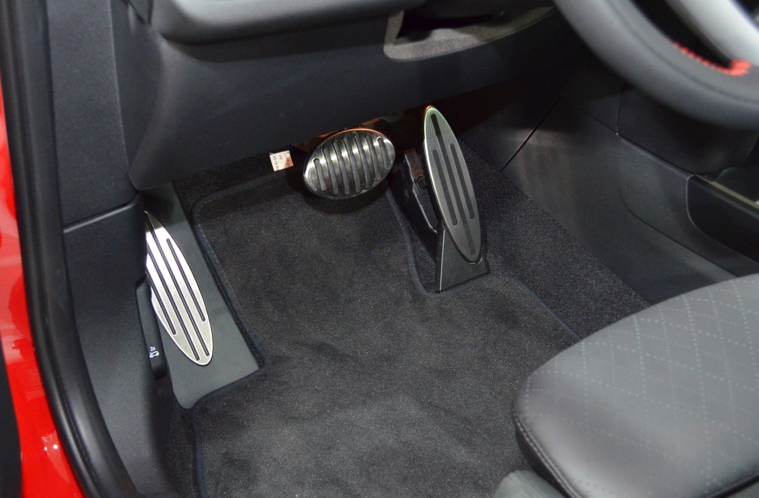 Pedals and footwell area with accelerator, brake, and footrest.