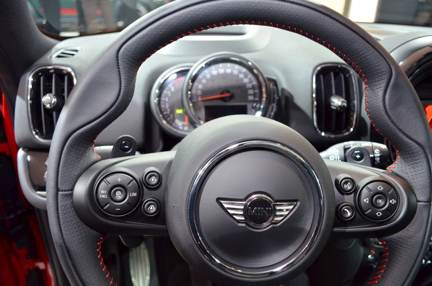 Steering wheel with multifunction buttons and dashboard with speedometer and air vents