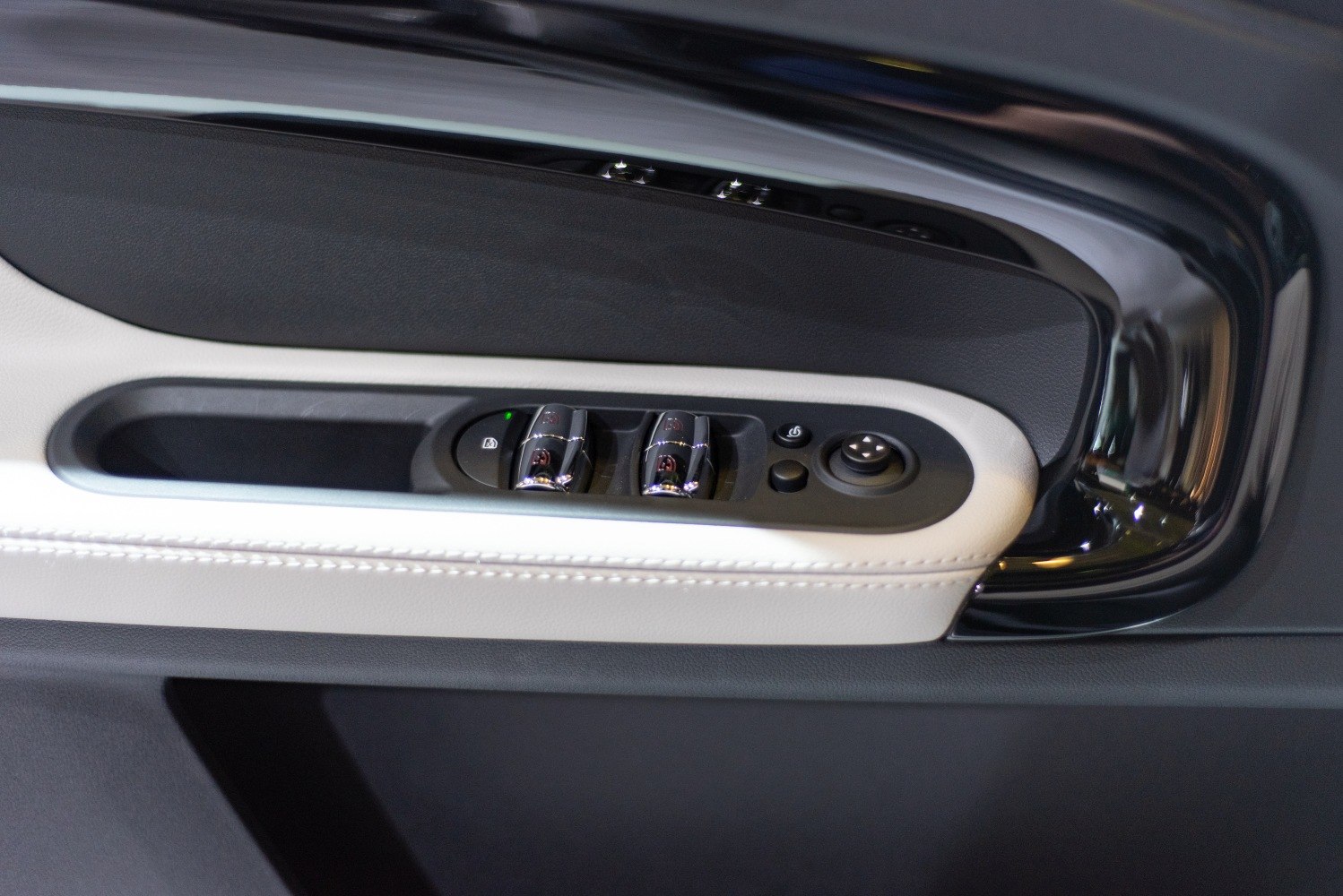 Close-up of interior door panel with window and mirror controls
