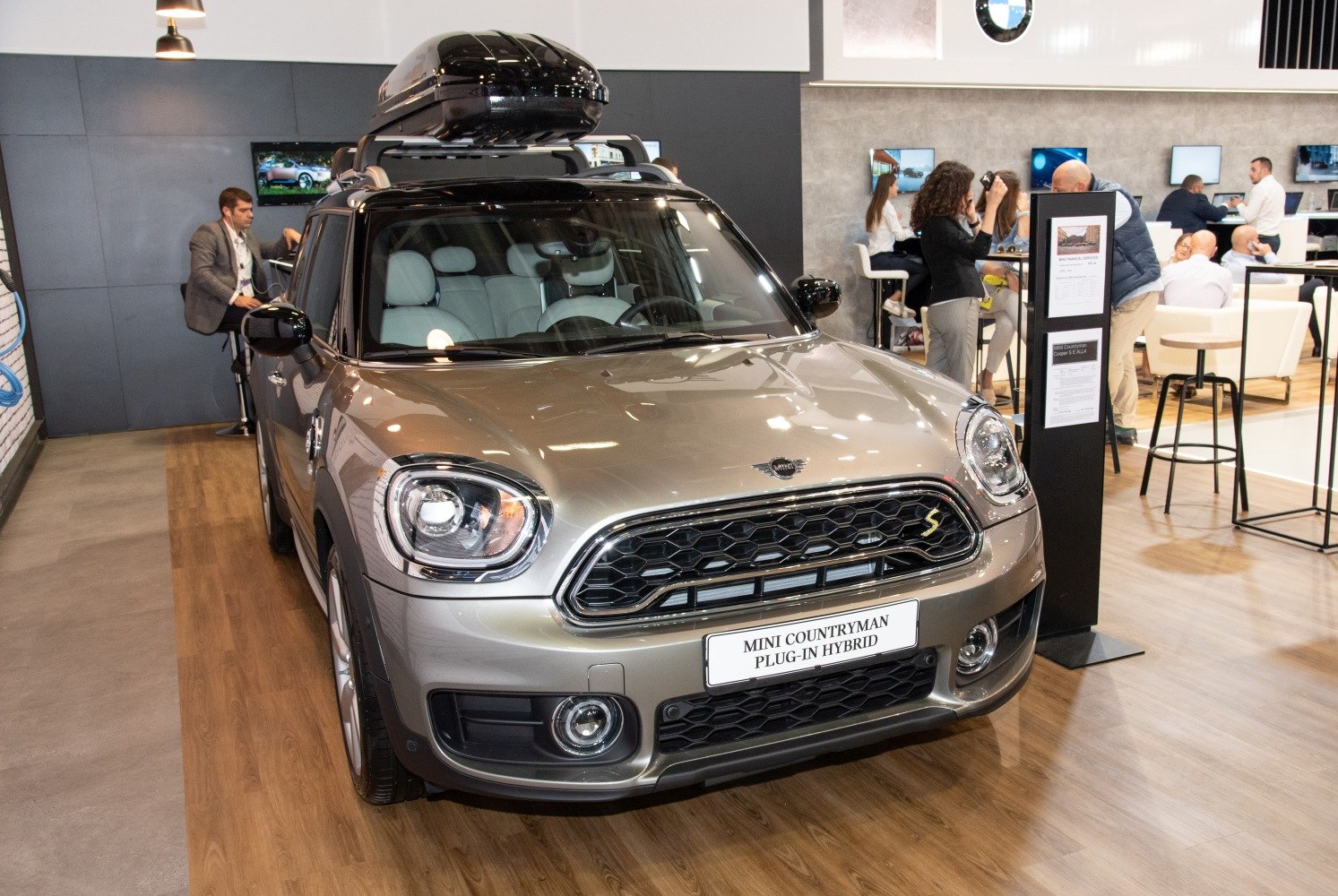 Front view of mini SUV with roof box and distinctive grille.