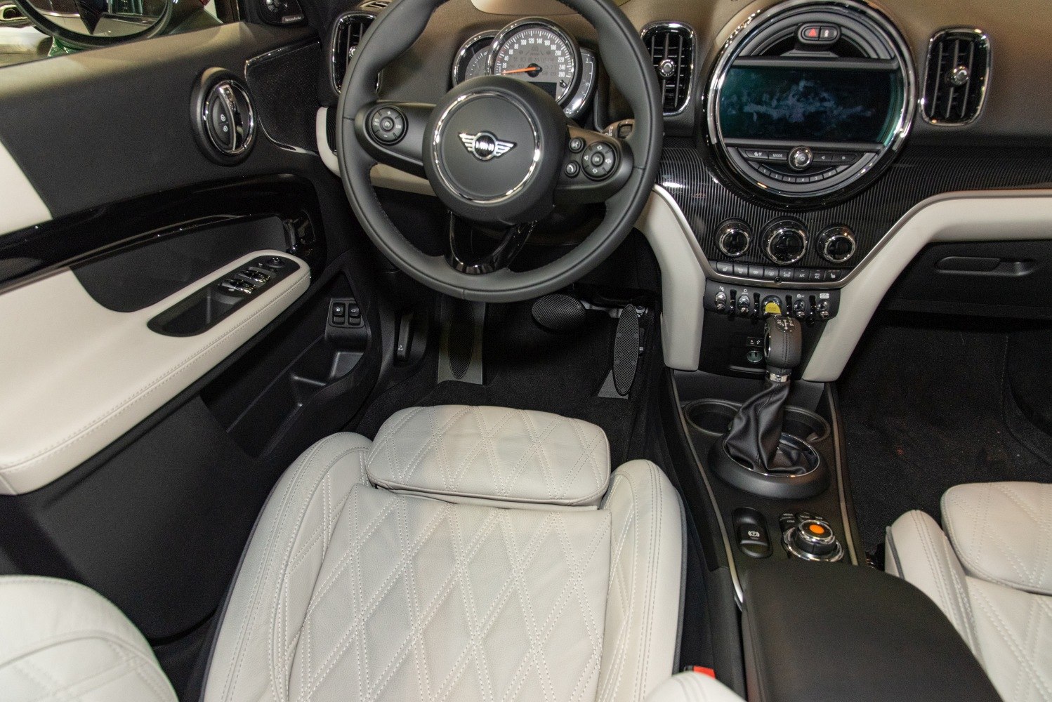 Luxury interior with white quilted leather seats and modern dashboard controls.