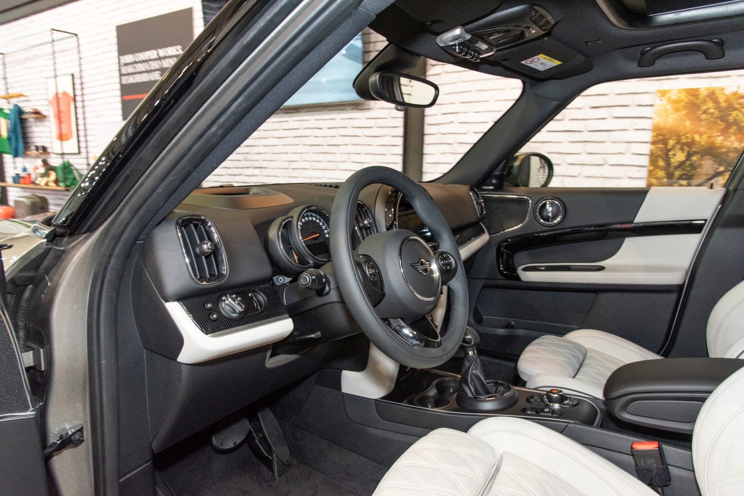 Luxury white leather seats and modern dashboard with steering wheel.