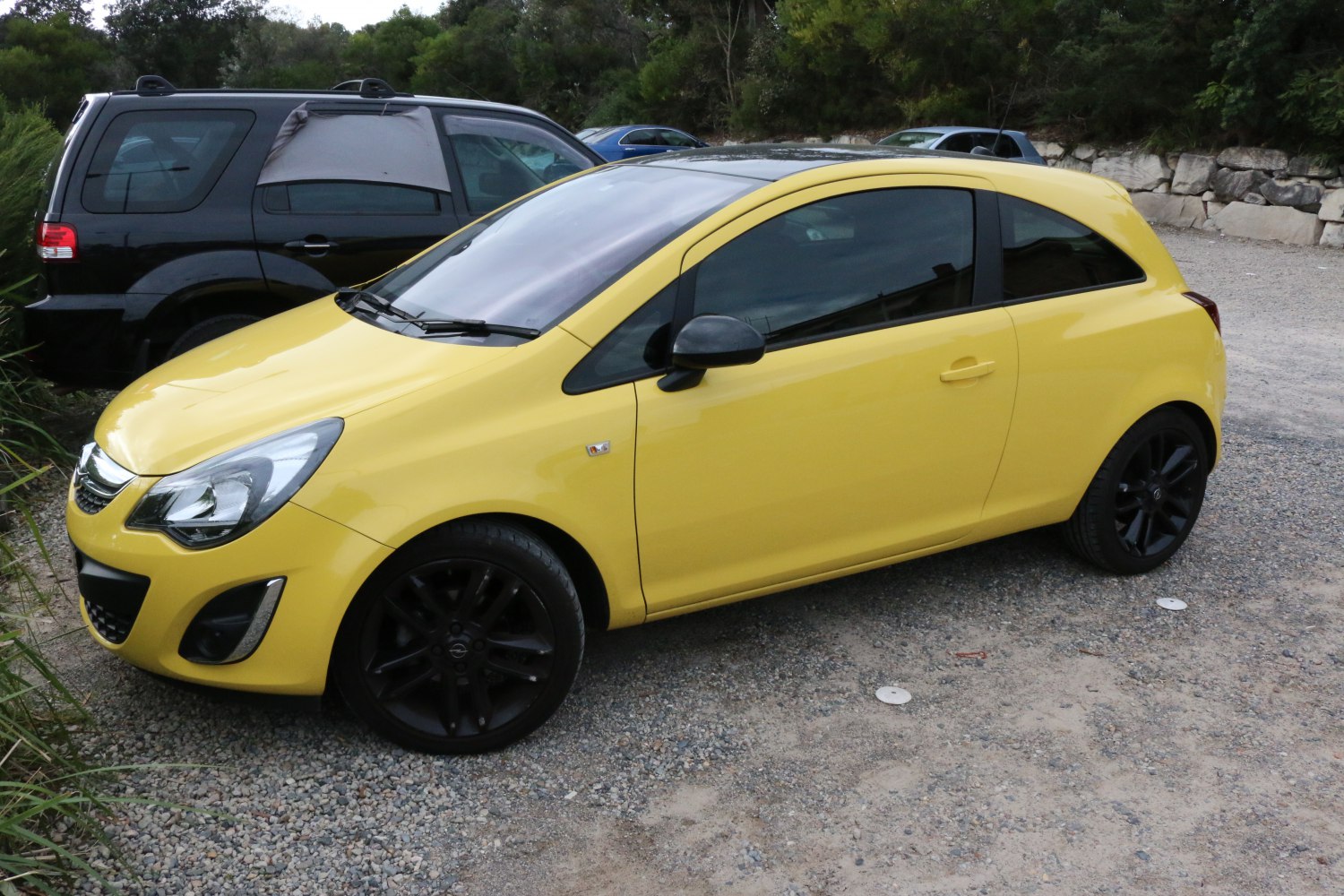 Yellow 3-door hatchback with black wheels and tinted windows