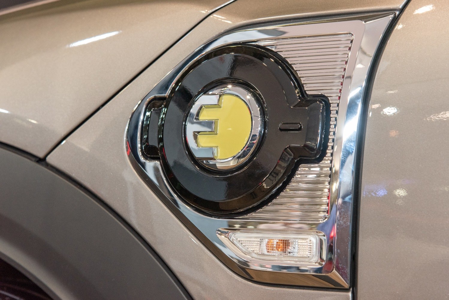 Close-up of an electric charging port emblem with a yellow plug symbol