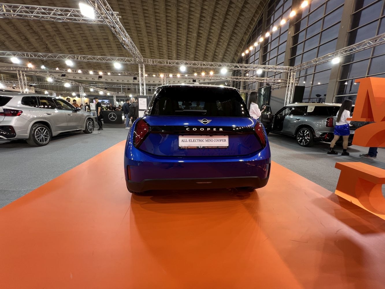 Rear view of a blue electric hatchback with modern taillights on display.