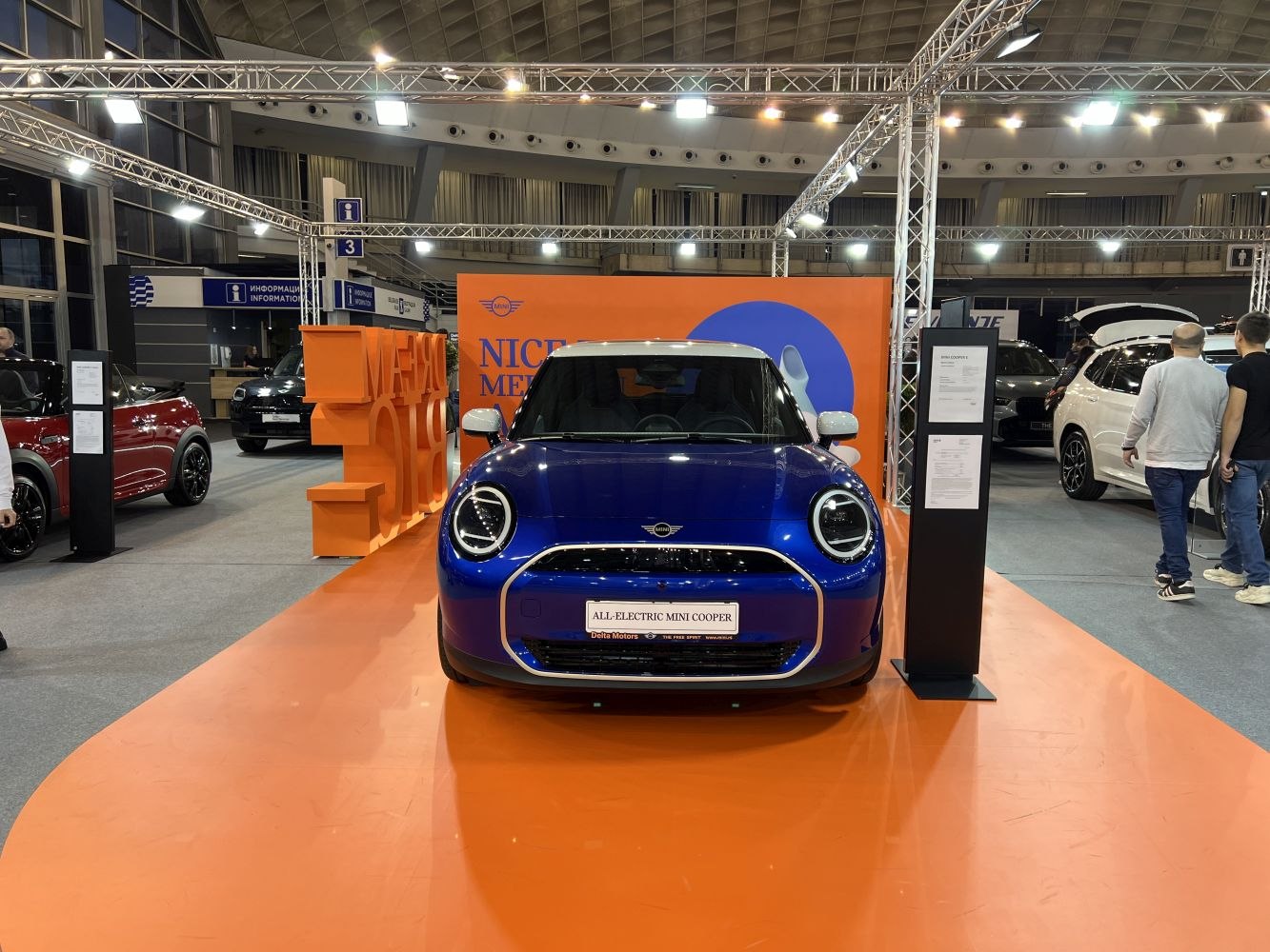 Front view featuring round LED headlights and modern grille on blue electric vehicle.