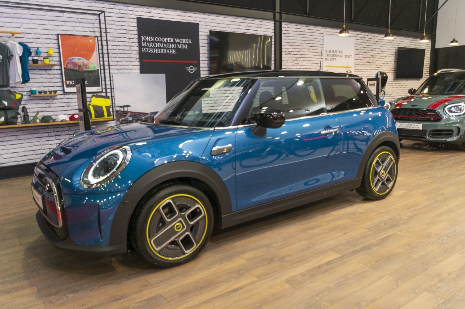 Compact electric hatchback with unique aerodynamic yellow-accented wheels.