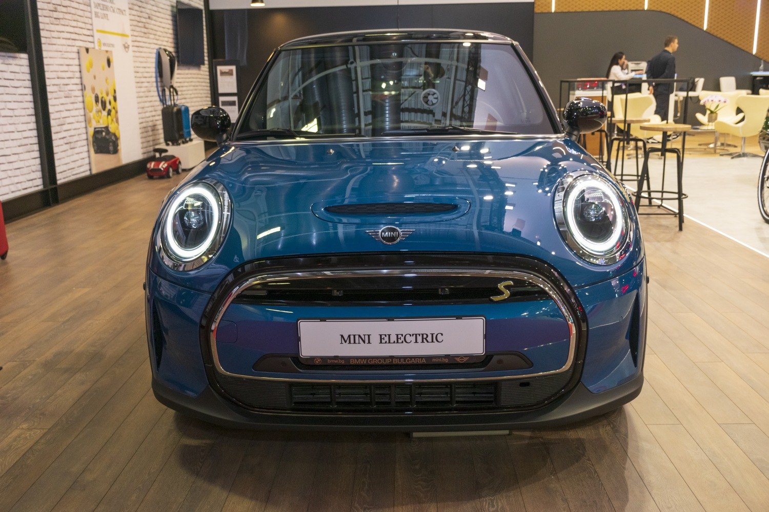 Front view with LED circular headlights and compact grille of a small electric hatchback