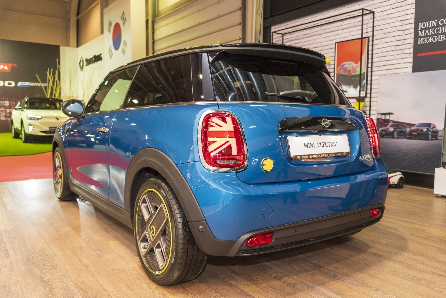 Rear view, Union Jack taillights, distinctive alloy wheels, blue electric hatchback
