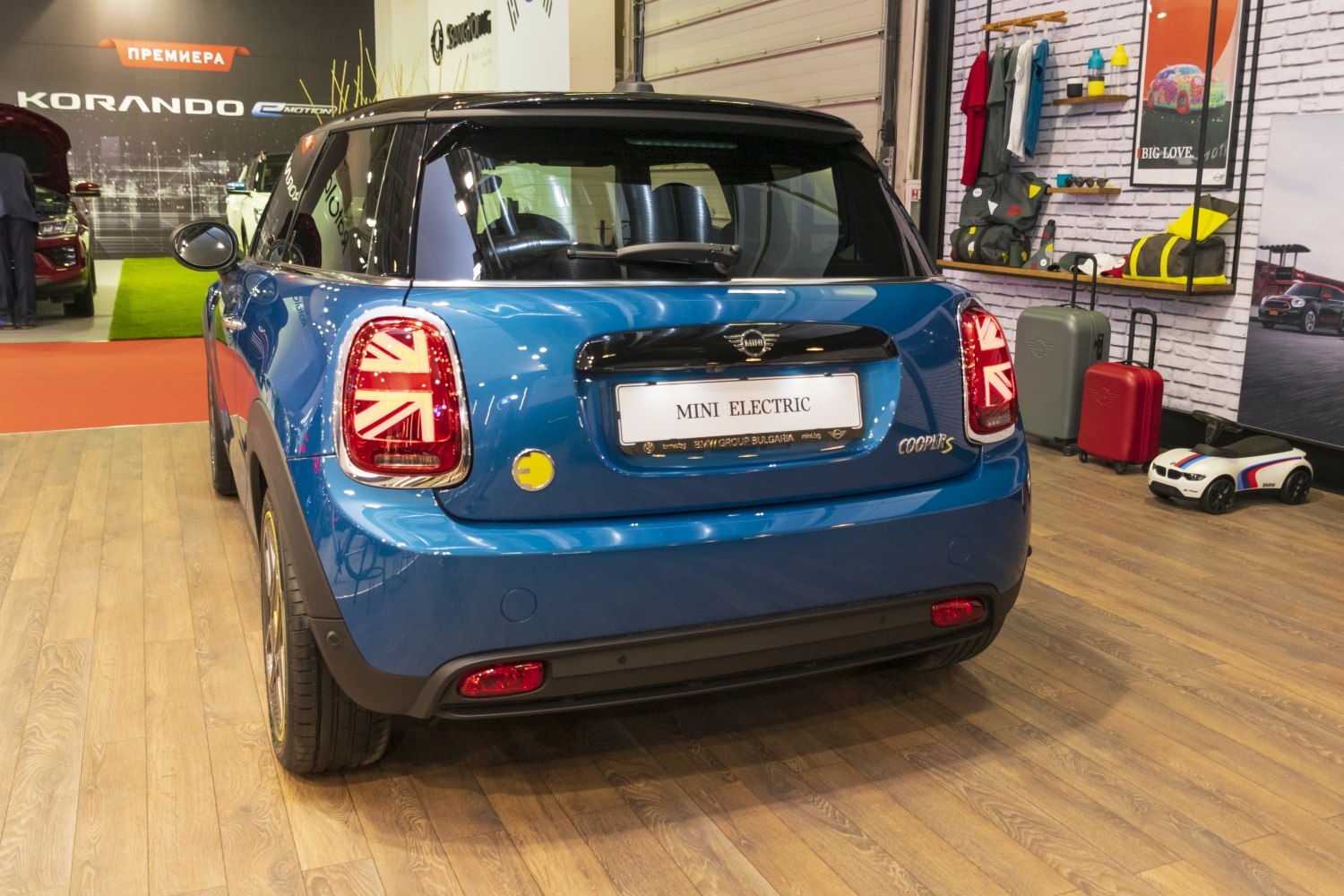 Rear view with Union Jack taillights and electric charging port on compact hatchback.
